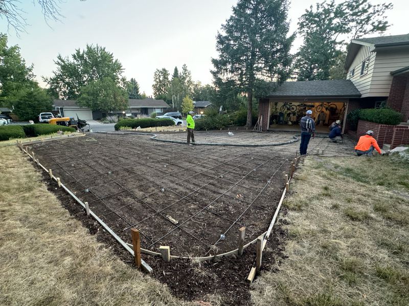 Crew setting forms and reinforcing over a compacted base for a large front slab
