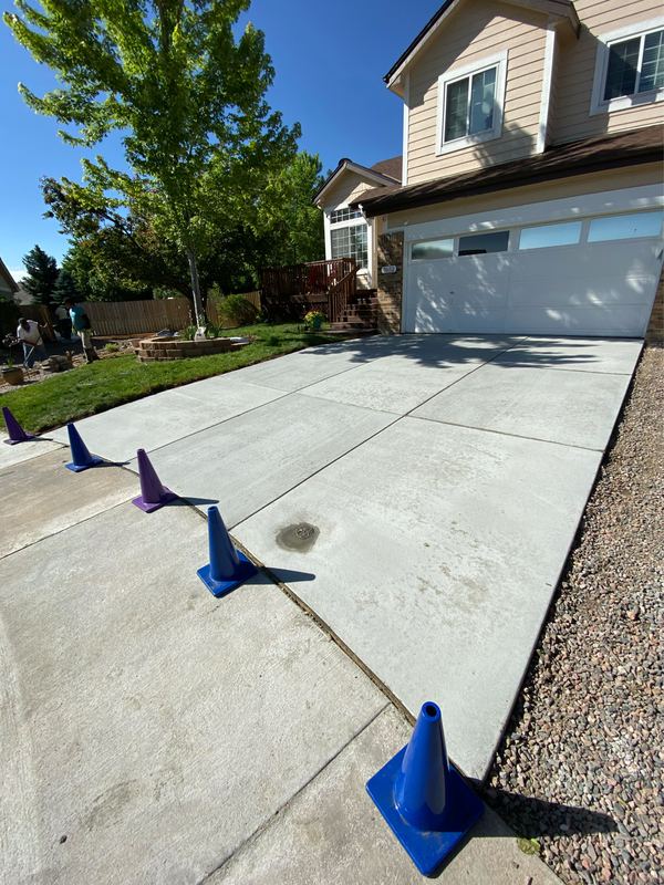 Finished concrete driveway with cones set out while the slab cures
