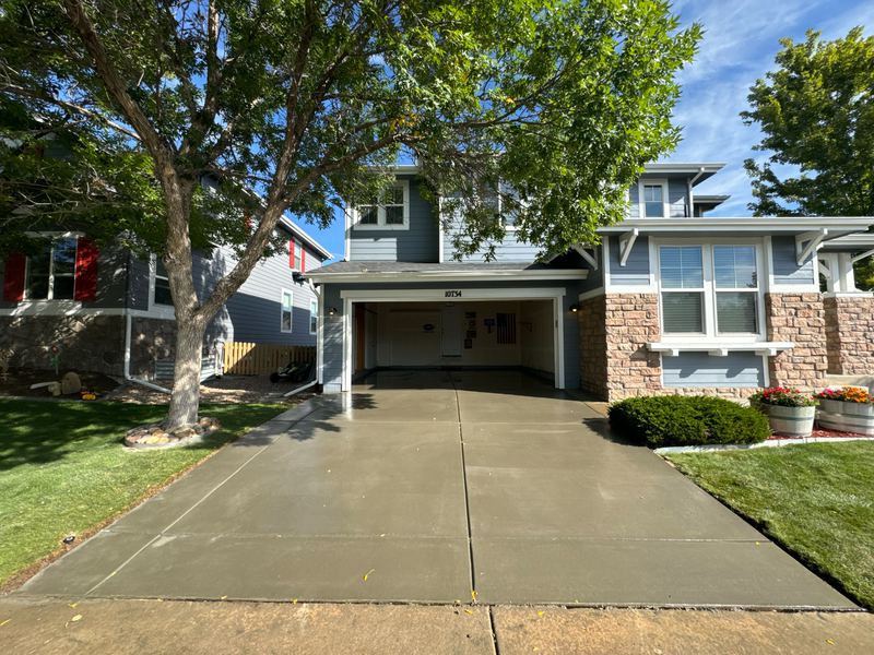 Finished concrete driveway leading to a two-car garage on a two-storey home