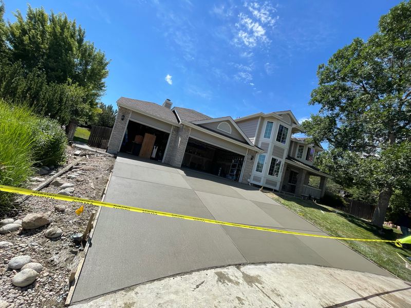 Sloped concrete driveway poured up to a three-car garage