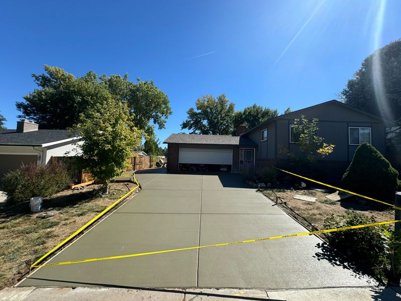 Wide concrete driveway freshly poured and taped off to cure