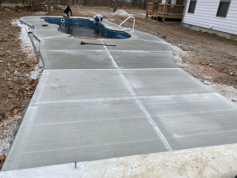 New broom-finished concrete pool deck poured around a freeform pool
