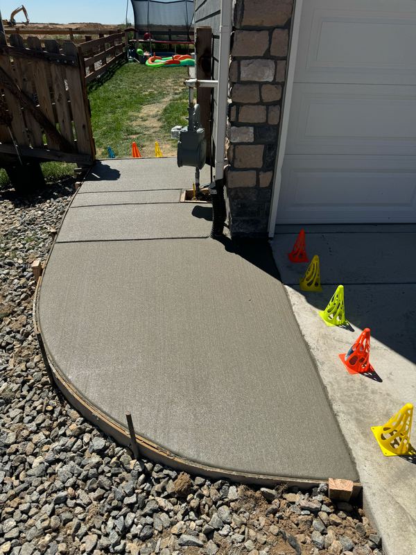 Curved concrete walkway and apron poured beside a garage